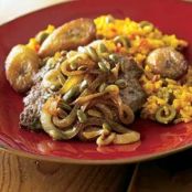 Cubed Beef Steaks With Onions and Pepitas Over Rice and Plantains