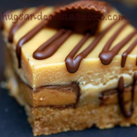 PEANUT BUTTER CHEESECAKE OVER PEANUT BUTTER CUPS SITTING ON A GRAHAM CRACKER CRUST & THEN TOPPED WITH PEANUT BUTTER GANACHE AND A CHOCOLATE DRIZZLE!
